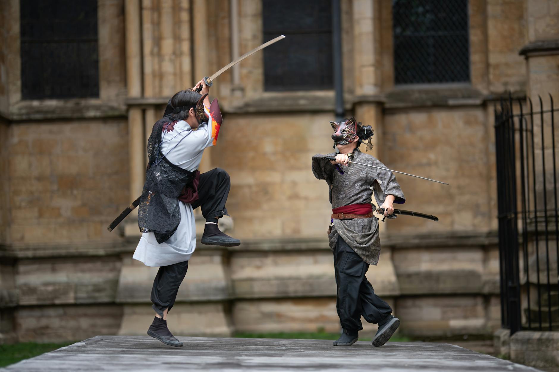 Dwóch samurajów w tradycyjnych strojach walczy na miecze w plenerze