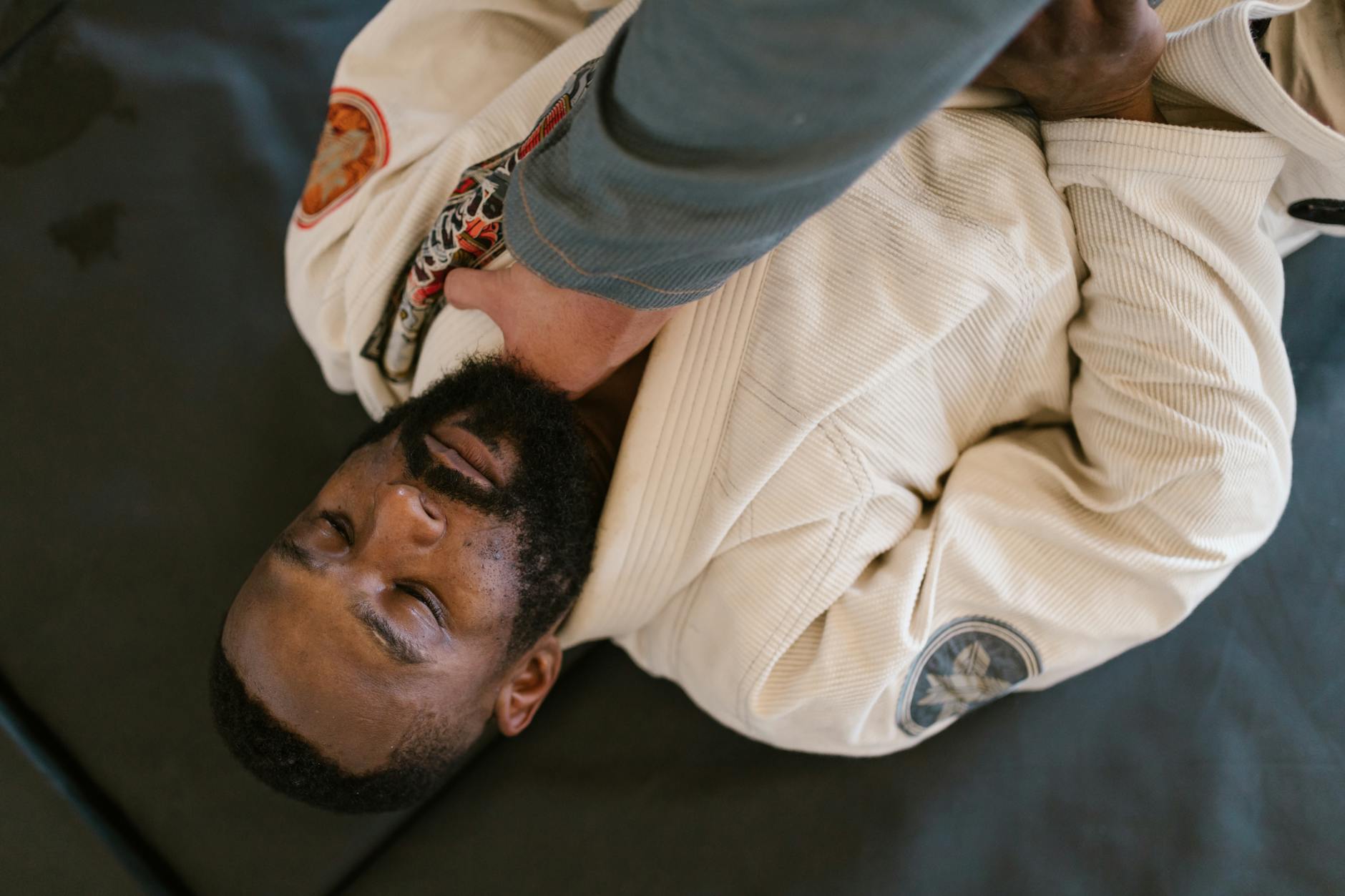 Zawodnicy karate i aikido ćwiczą techniki ne-waza na macie