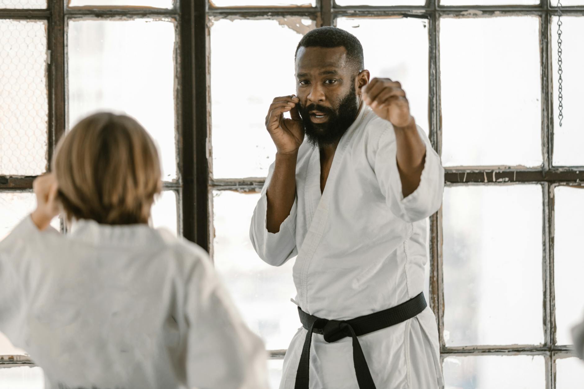 Adepty sztuk walki ćwiczą technikę w jasnym dojo