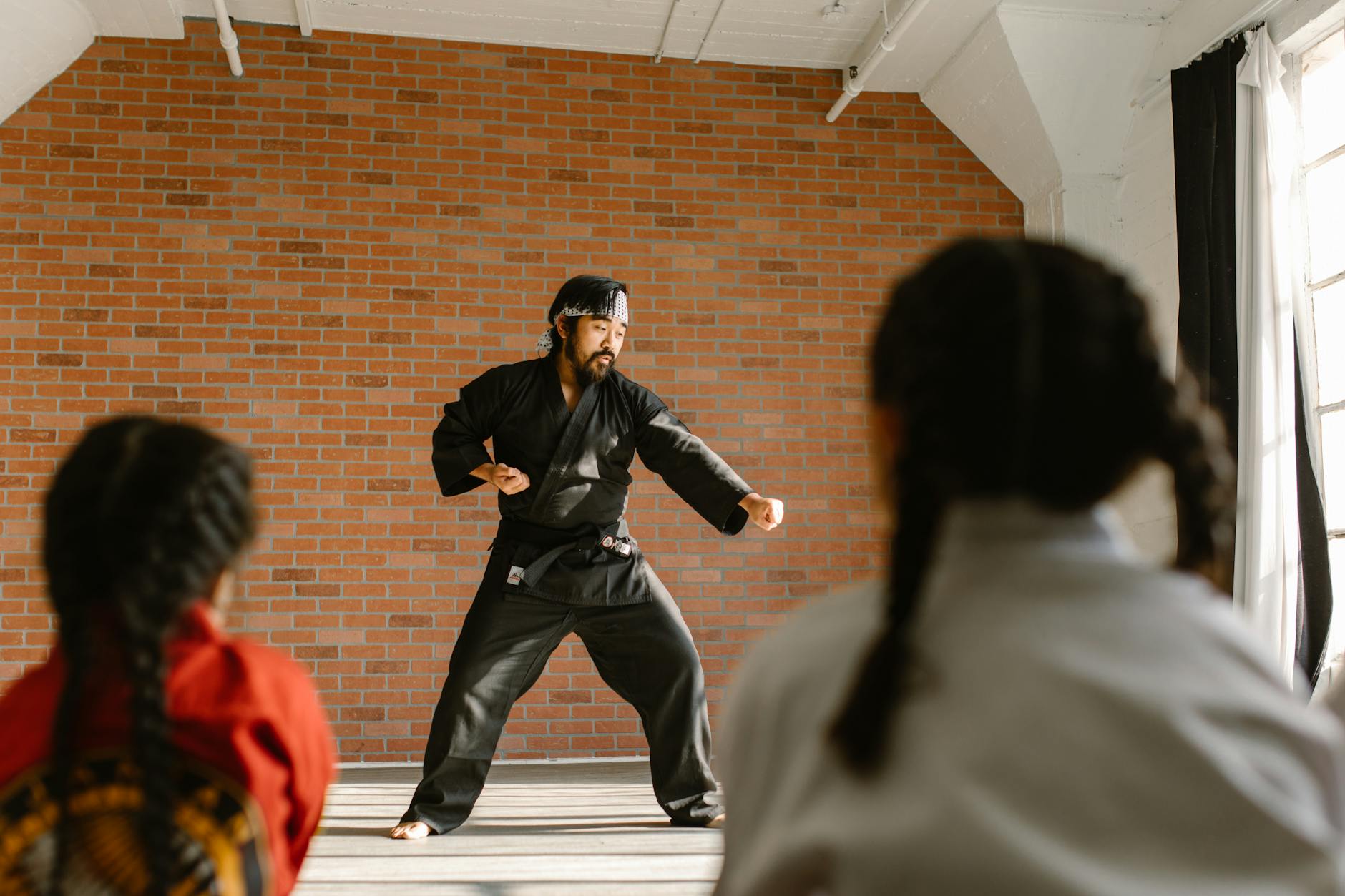 Instruktor budō pokazuje techniki młodym adeptom w dojo