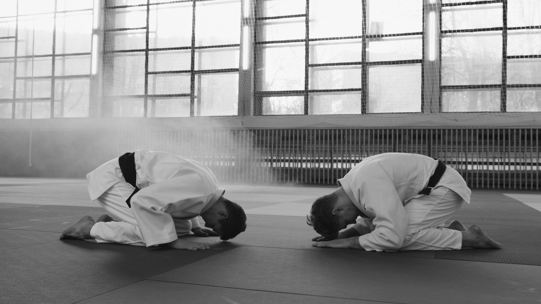 Etykieta dojo a ego: jak zasady zachowania pomagają oswoić ambicję i chęć dominacji Dwóch zawodników sztuk walki kłania się w sali treningowej