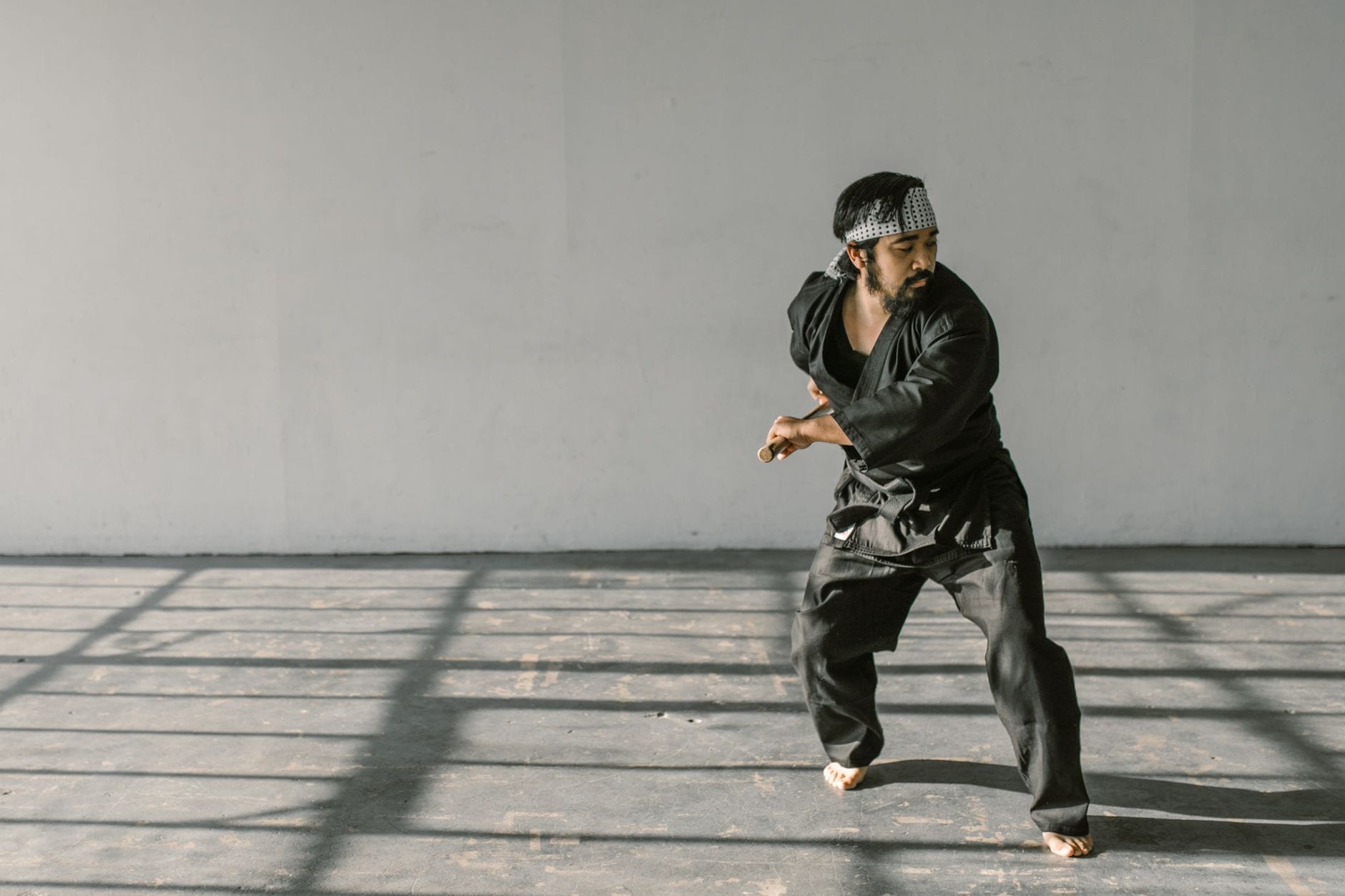 Praktykujący jujutsu w czarnym gi trenuje techniki w dojo