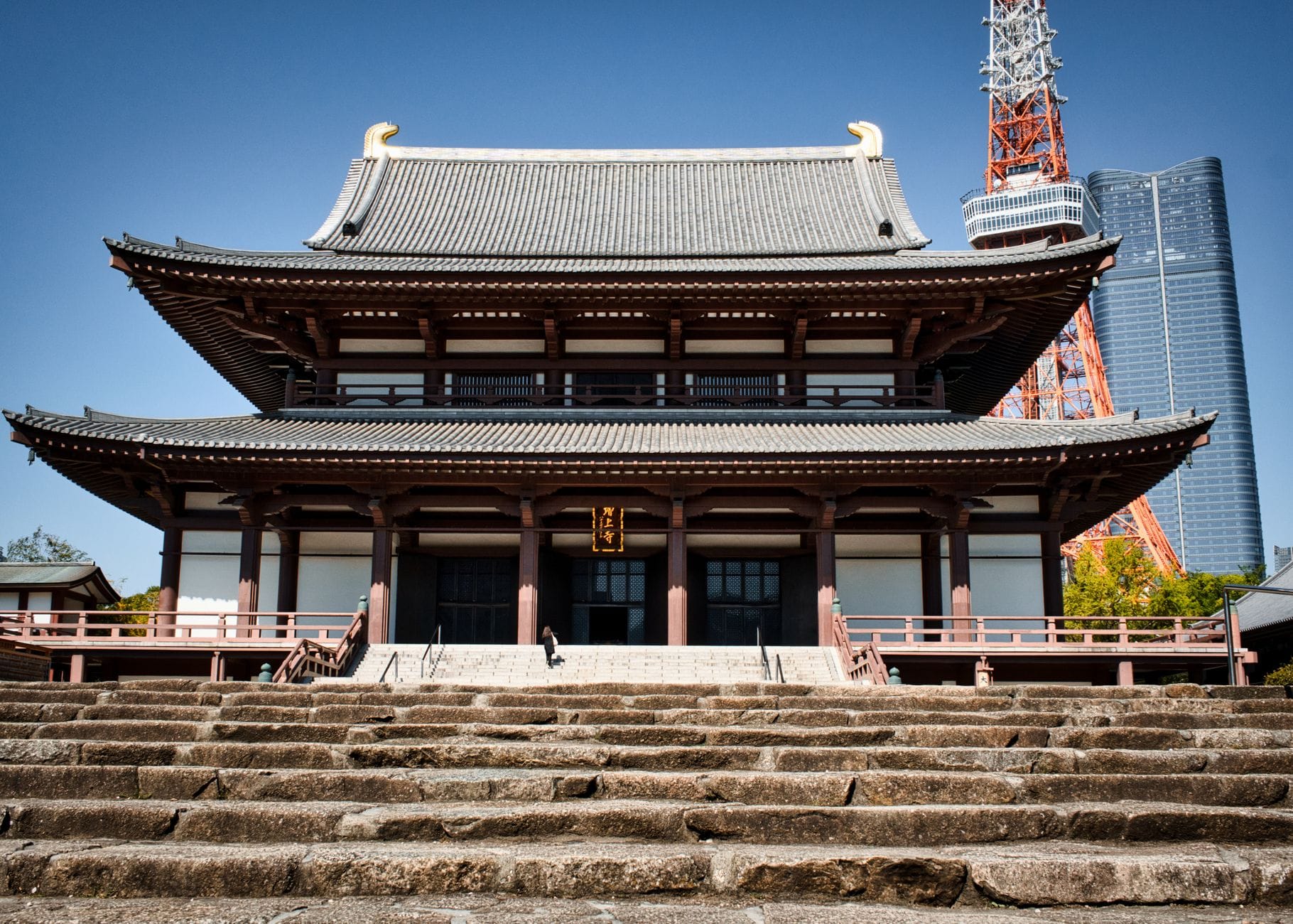 Świątynia Zojoji w Tokio z Tokyo Tower w tle pod błękitnym niebem